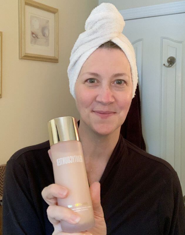 Tina holding Hydrating Essence, Step 2 of the skincare routine for mature skin.