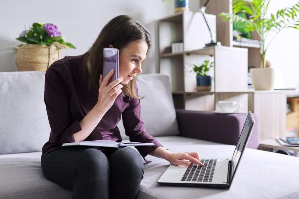 Woman working on cellphone and laptop with blue light