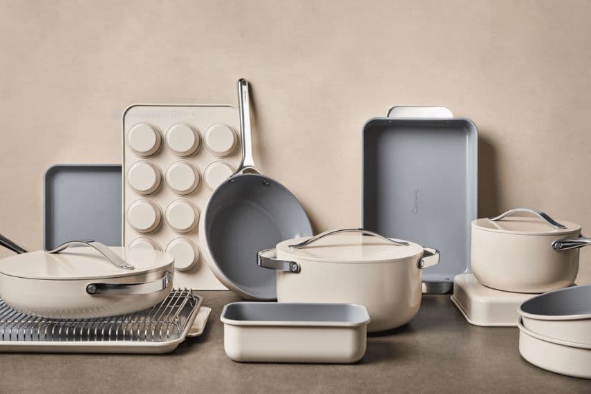 Cream-colored Caraway non-toxic cook and bake set with pots, pans, baking trays, and muffin tin.