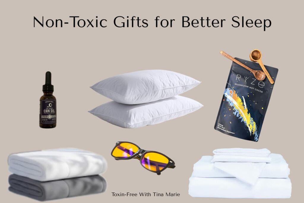 Non-toxic sleep gifts include a bottle of oil, two white pillows, Ryze mushroom hot cocoa, a folded blanket, orange-tinted glasses, and a white sheet set.
