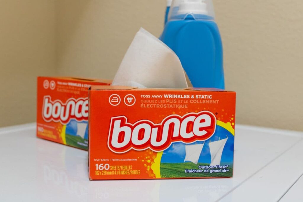 Bounce conventional dryer sheets and bottle of detergent on washing machine.
