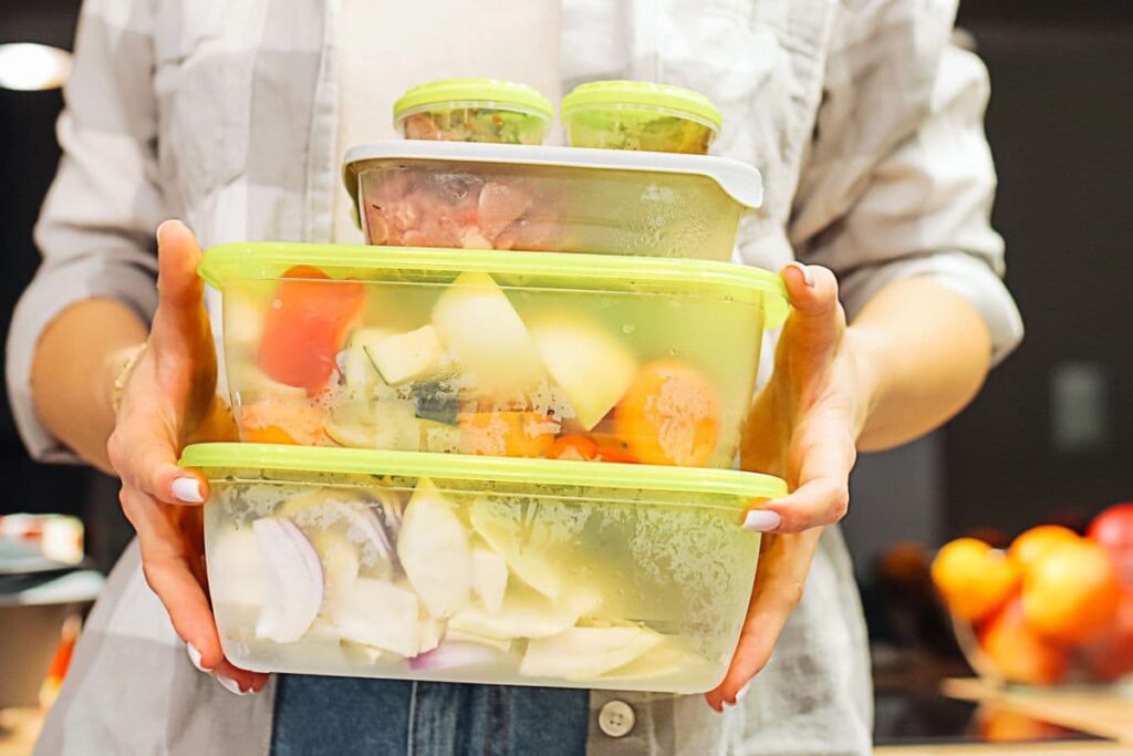 Woman holding plastic food storge containers with hot food and condensation: rate them using the SAFE Framework.