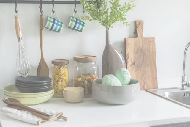 kitchen counter with non-toxic tools, bowls, mugs, and cutting board
