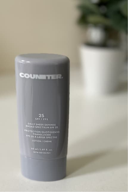 Counter sheer defense mineral sunscreen on table with plant out of focus in background