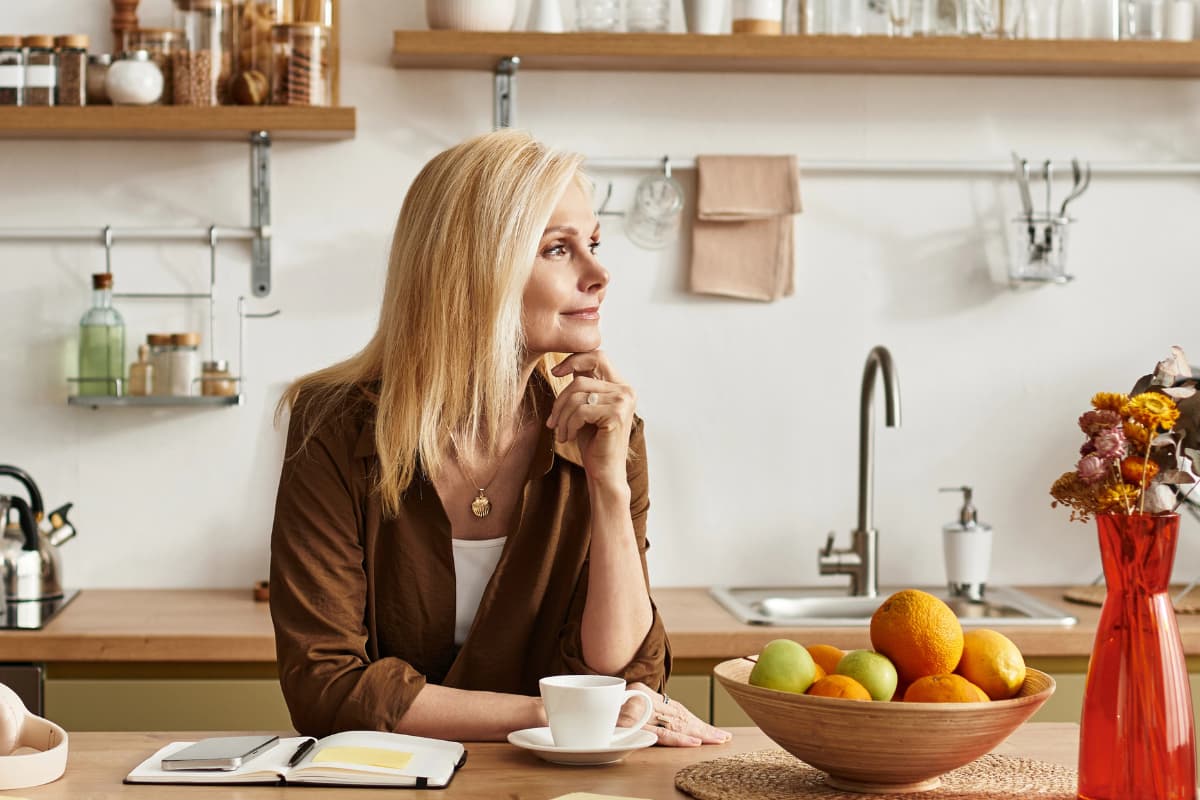 Woman sitting at a kitchen counter while considering where to start with non-toxic living