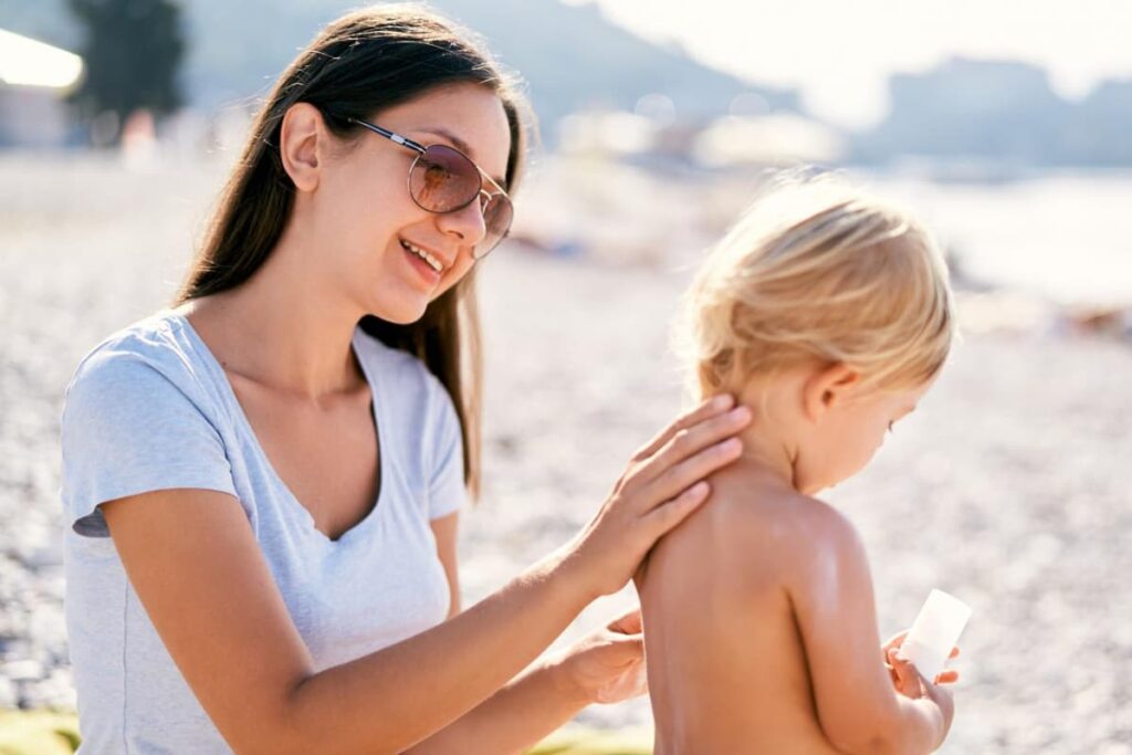 Mom applying safe mineral sunscreen to her child.