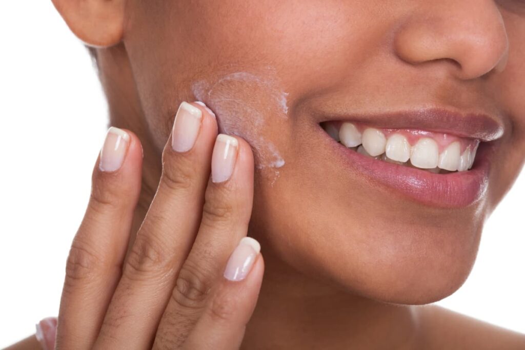 Woman applying moisturizer, an example of a skincare product that stays on your skin.